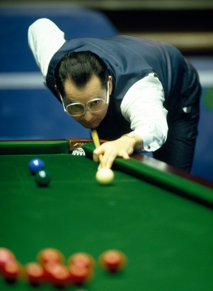 a man wearing glasses is playing pool on a green table