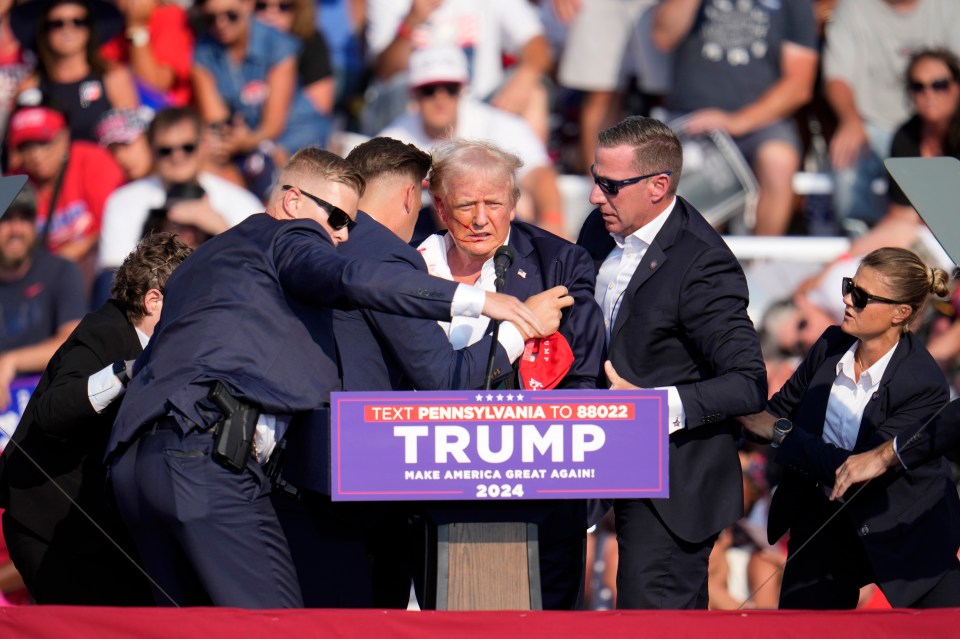 Secret Service agents go to tackle Trump to the ground after he was shot at a rally in July