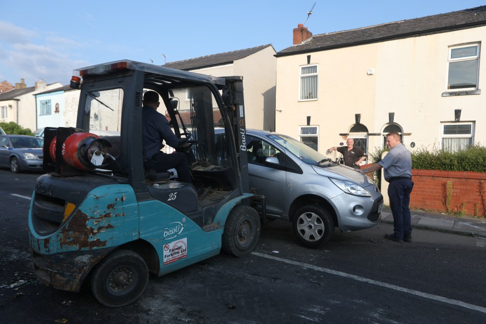 Rescue workers remove a damaged vehicle from Sussex Road