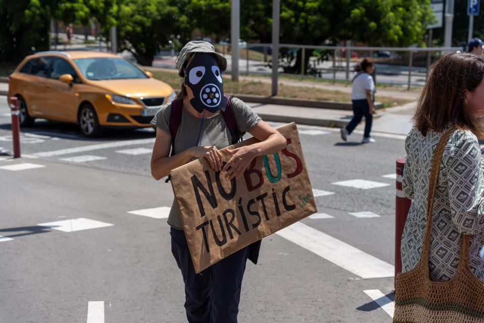 A protester has their face covered holding a sign