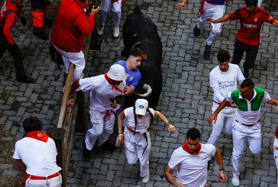 Moment one of the revellers was hit by an angry bull during the daring sprint