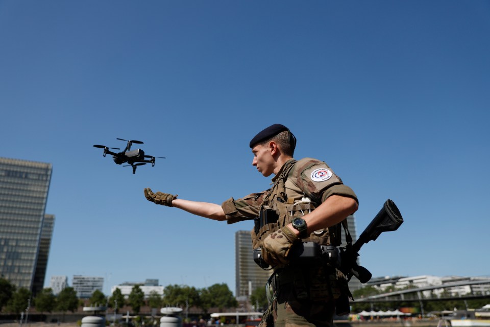 A soldier launches a drone over the Seine River