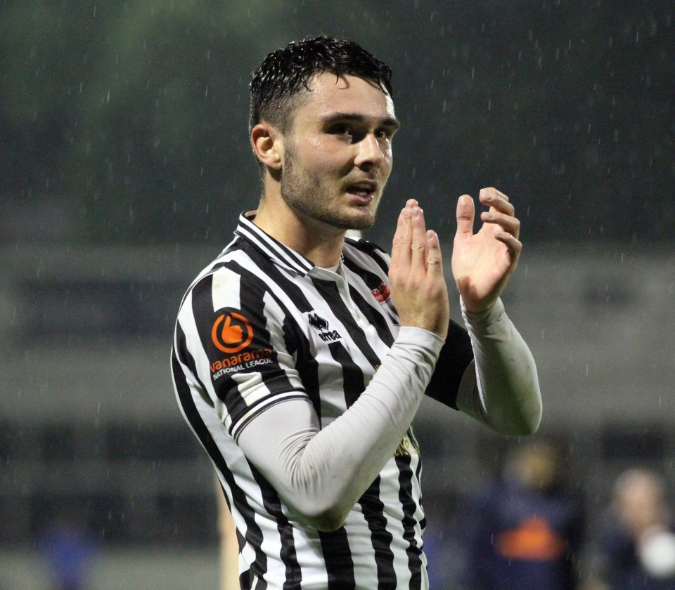 a man wearing a black and white striped jersey with an orange g on it