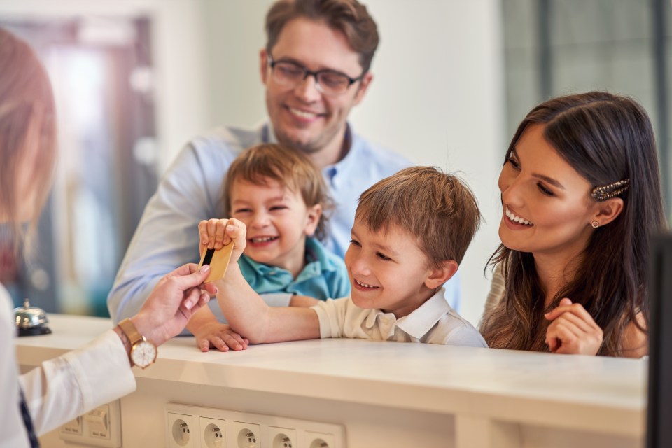 Picture of happy family checking in hotel