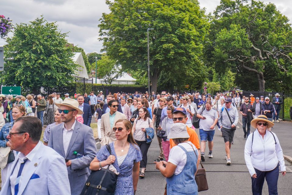 a crowd of people are walking down a street in front of a sign that says ' no parking '