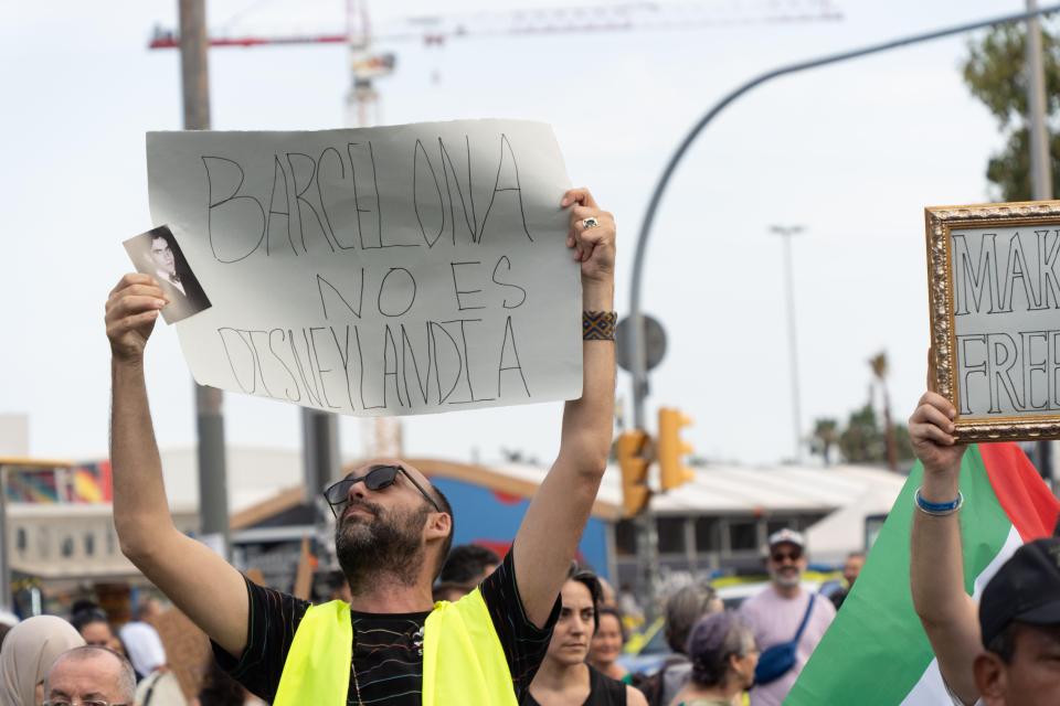 A local proudly holds up their poster that says 'Barcelona is not Disneyland'