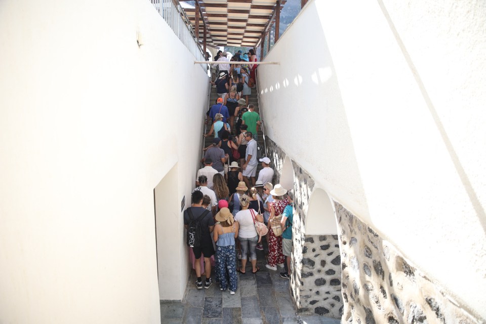 Tourists queue as they wait to get the cable car for a tour