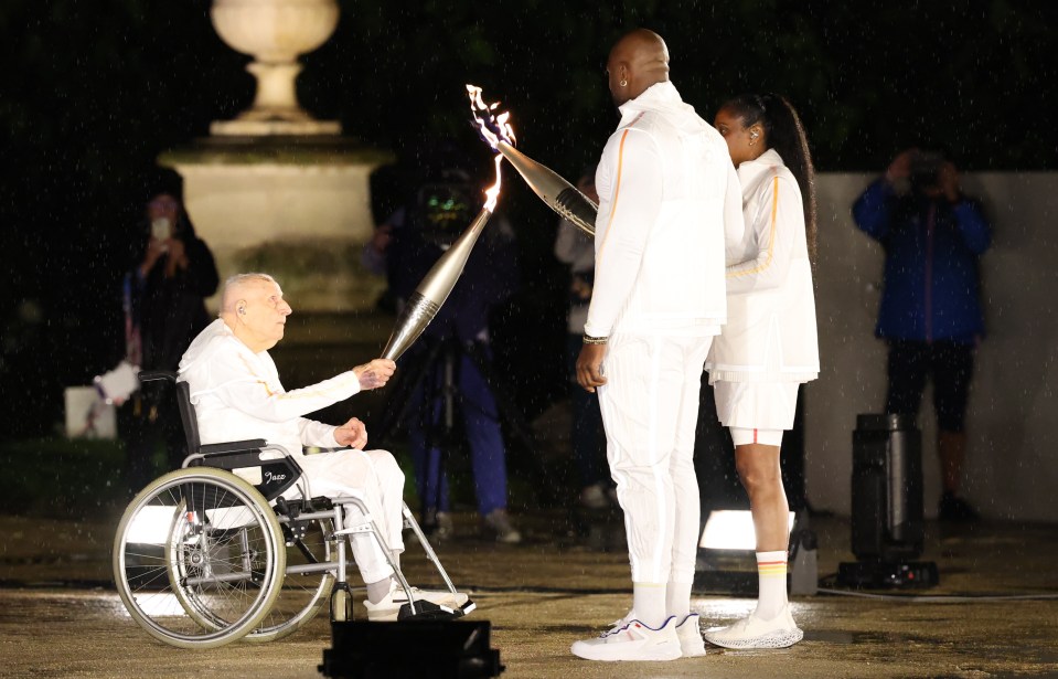 a man in a wheelchair is being lit up by a torch