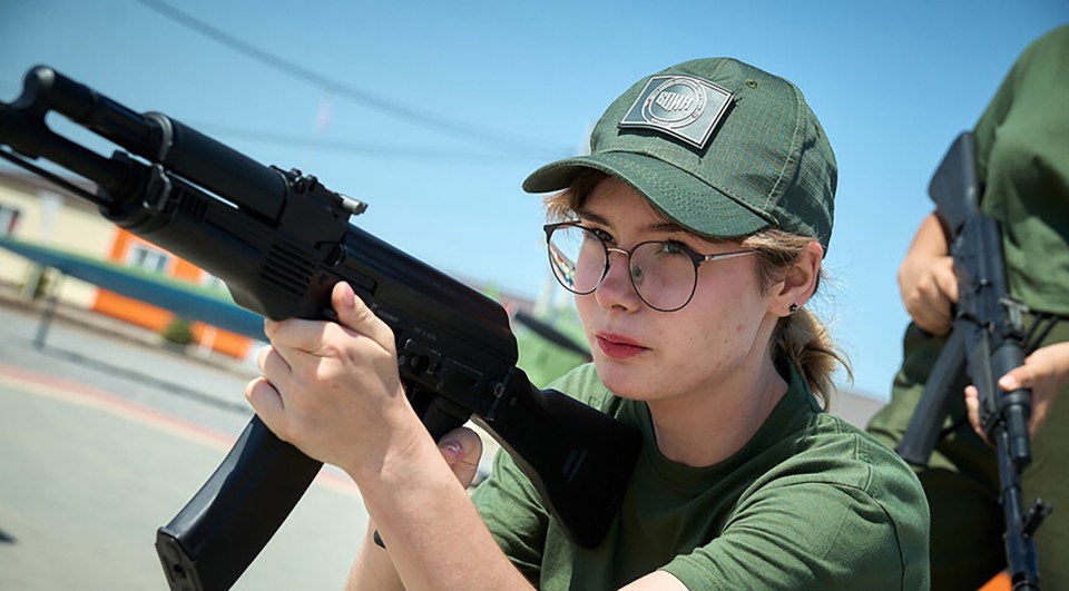 A young kid from occupied Ukraine firing a Kalashnikov assault rifle during Russian military training in special camps.