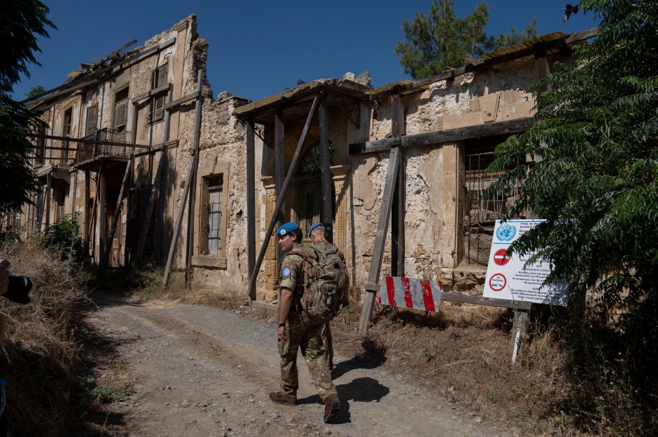 a man in a blue beret stands in front of a building