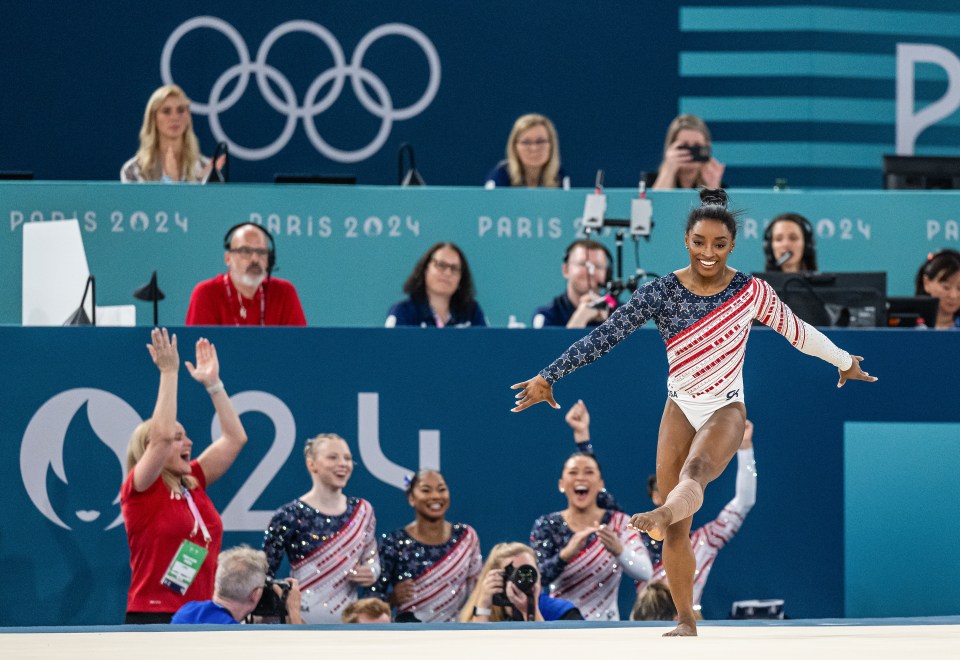 a gymnast performs on the floor in front of a sign that says paris 2024