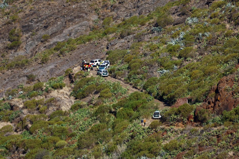 a group of cars are parked on the side of a hill