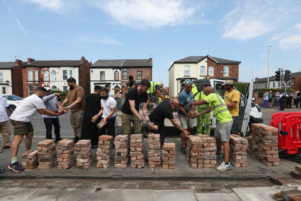 Volunteers rebuild the wall outside Southport Islamic Society Mosque