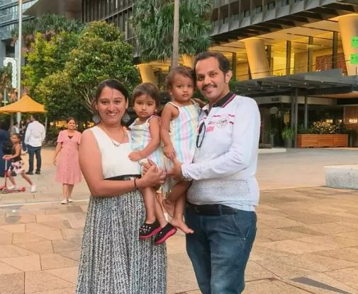 Poonam and Anand beaming as they held their twins wearing matching dresses