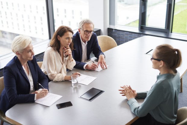 a woman is being interviewed by a group of people