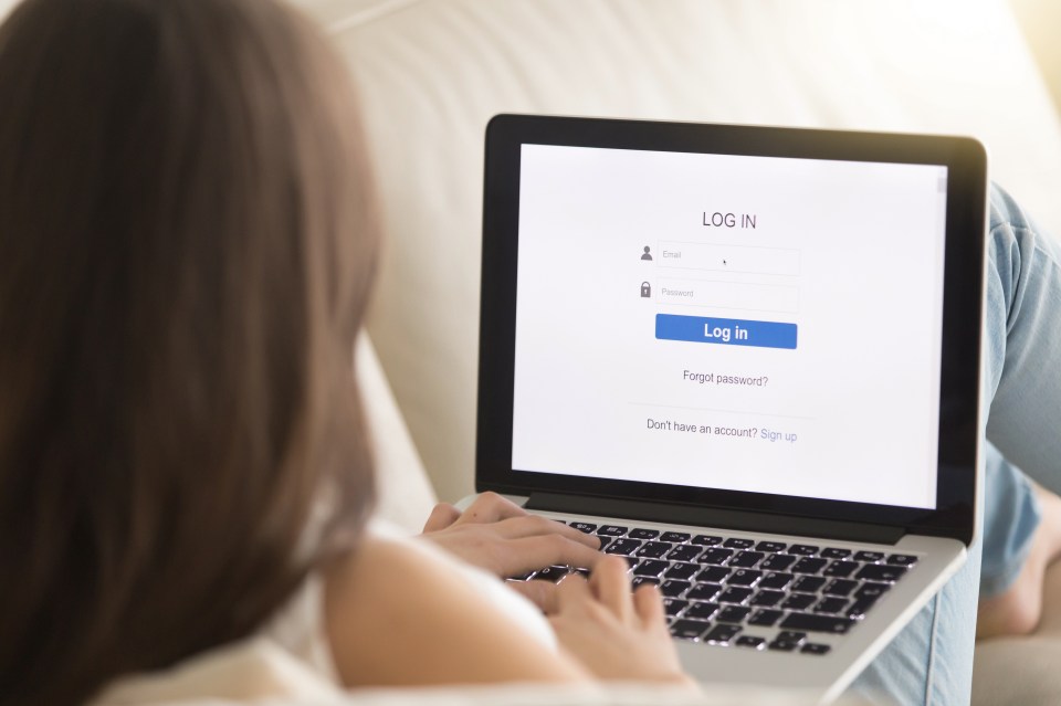 a woman is using a laptop with a log in page open