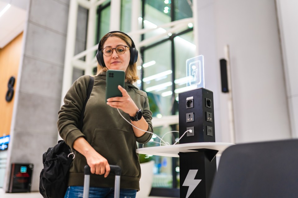 a woman wearing headphones is looking at her phone