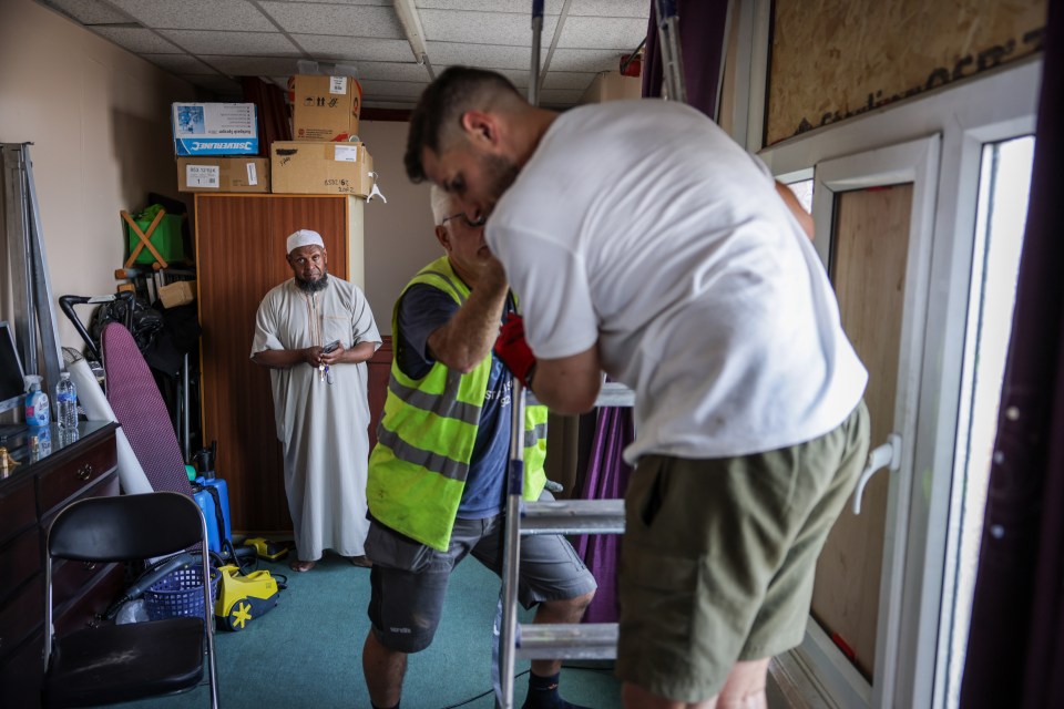 Workers repair a window in the roof of Southport Islamic Centre Mosque