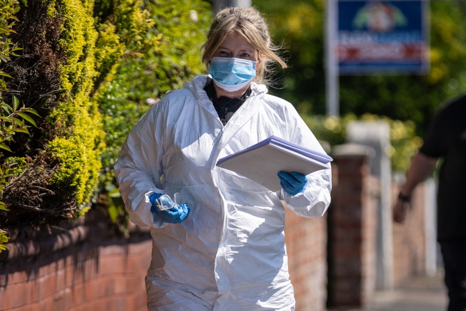 a woman wearing a mask and gloves is walking down the street