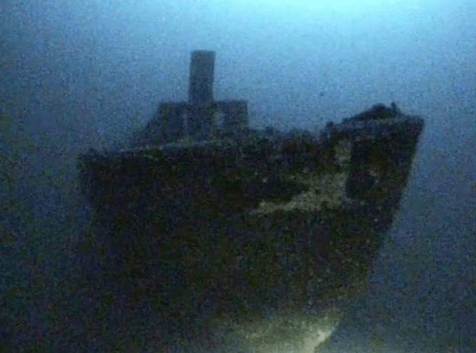 a large ship is floating on top of a body of water .