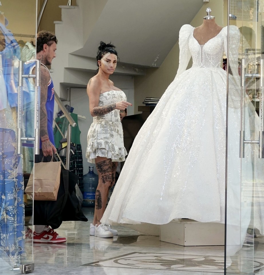 a woman is looking at a wedding dress in a store