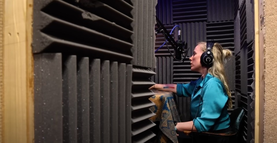 a woman wearing headphones is singing into a microphone