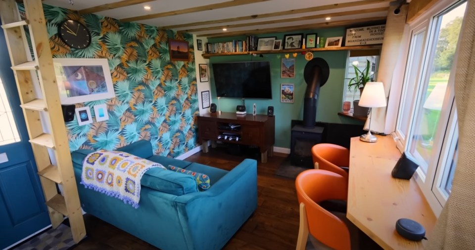 a living room with a blue couch and orange chairs