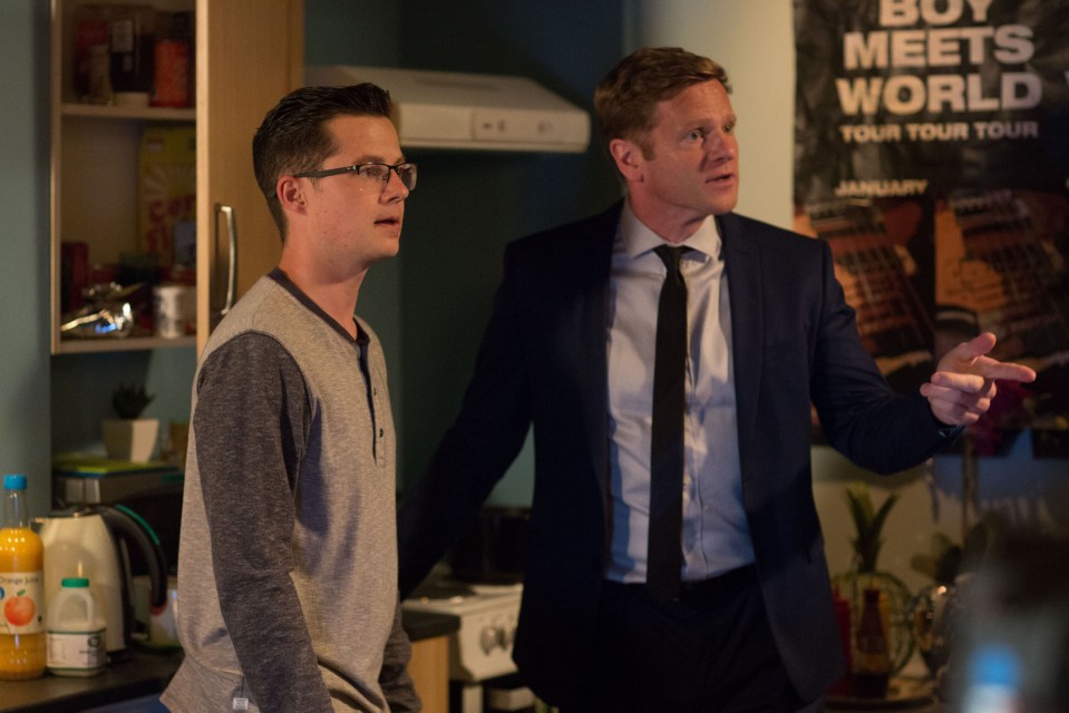 two men standing in front of a poster that says buy meets world