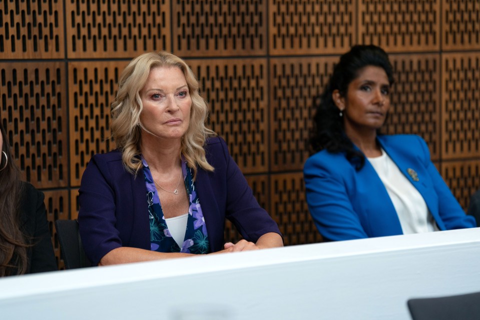 a woman in a purple jacket sits next to another woman in a blue jacket