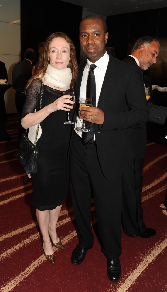 a man and a woman standing next to each other holding wine glasses