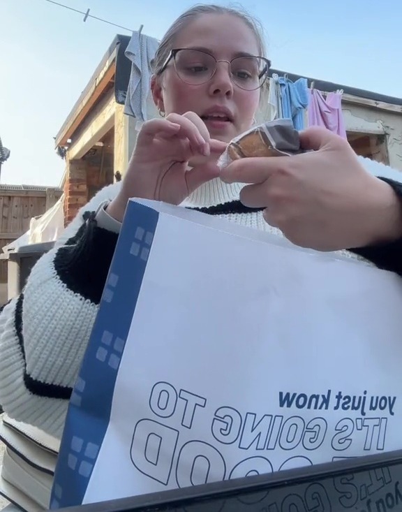 a girl holding a bag that says too good to go bag