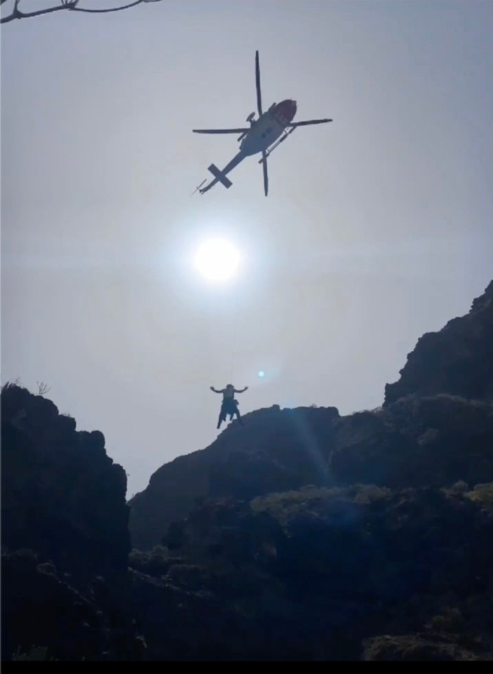 The moment a helicopter crewman was winched into the ravine with his arms aloft in the delicate recovery operation