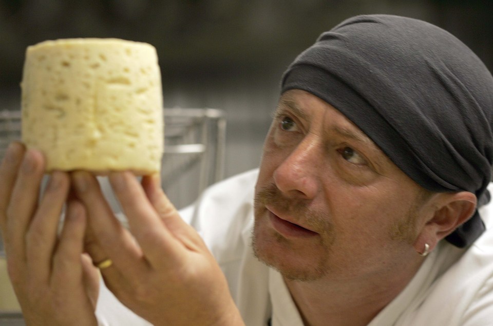 a man wearing a black headband is holding a piece of cheese