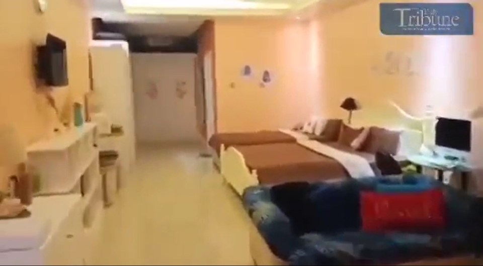 a hotel room with three beds and a couch .