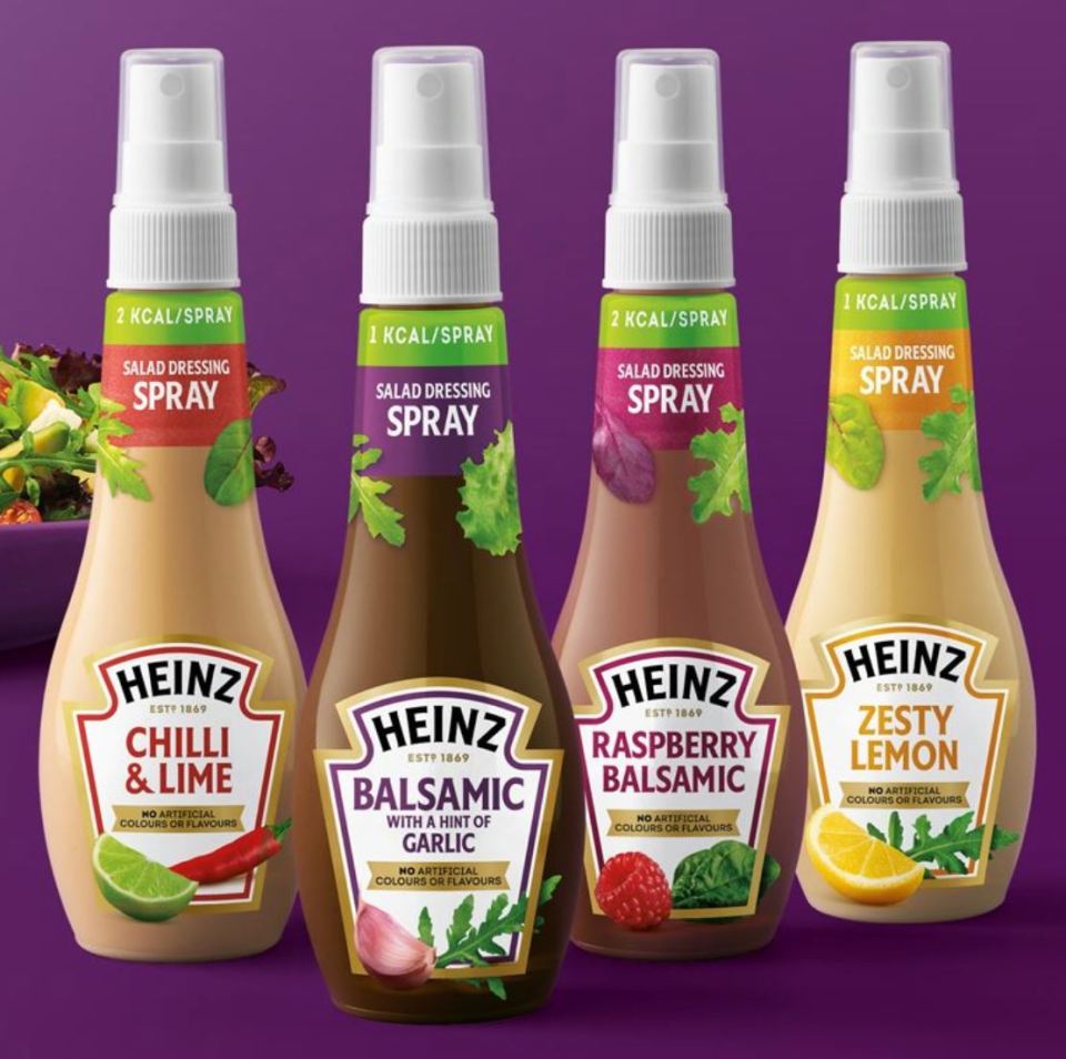 four bottles of heinz salad dressing spray on a purple background