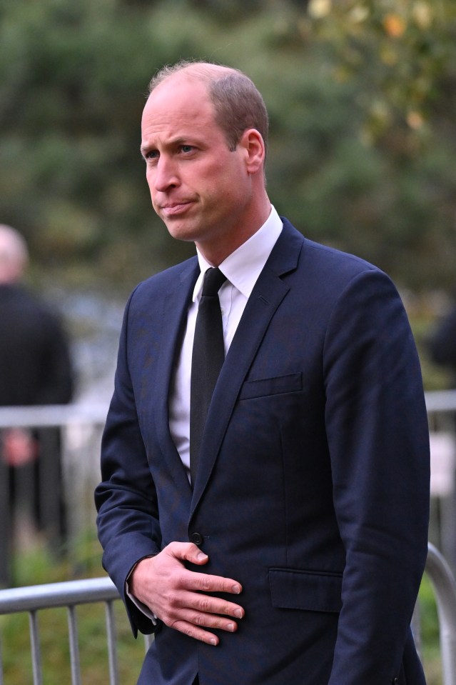 a man in a suit and tie has his hand on his stomach