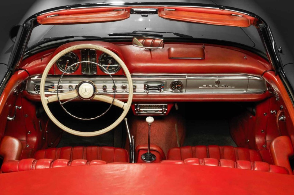 The interior is trimmed with striking red leather