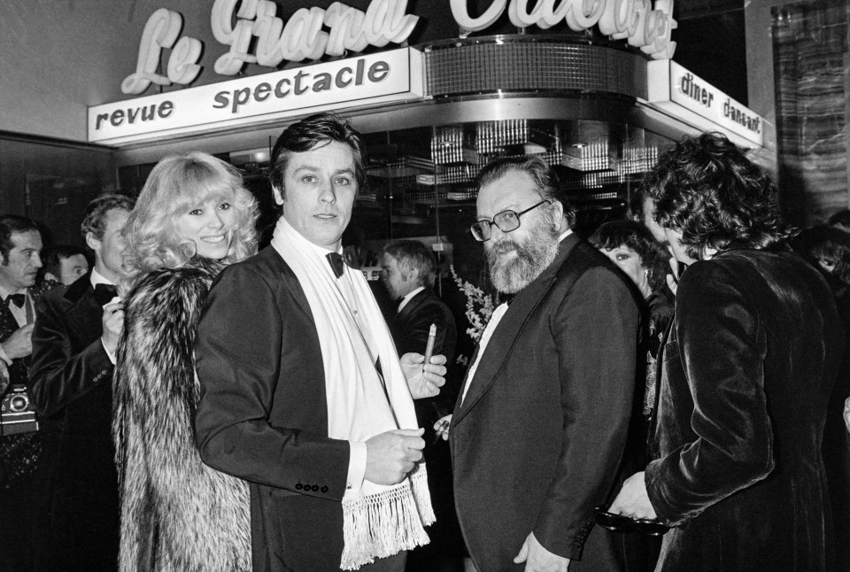 a group of people standing in front of a sign that says revue spectacle