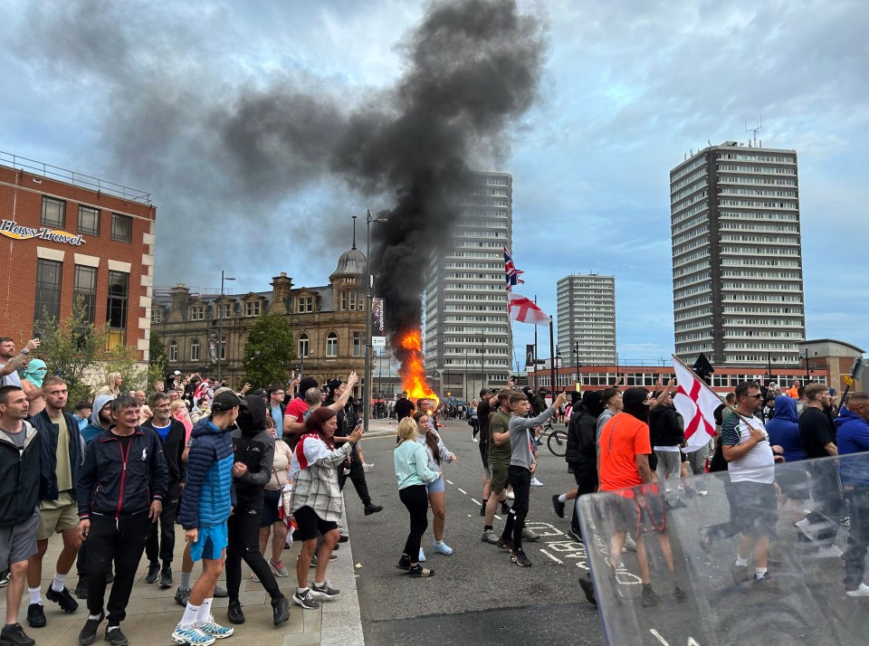 Flames rose from a torched car as rioters gathered in Sunderland