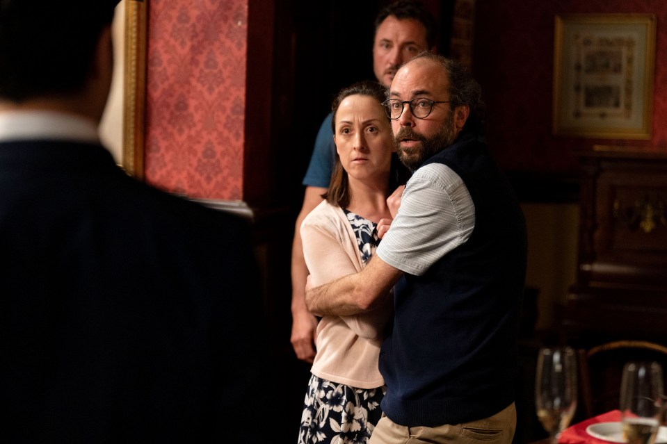 a man and a woman are standing next to each other in a dark room