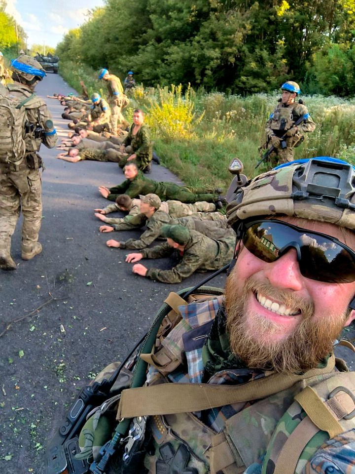 a group of soldiers are laying on the ground and one of them is smiling