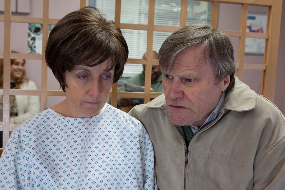 a man and a woman are standing next to each other in a hospital room