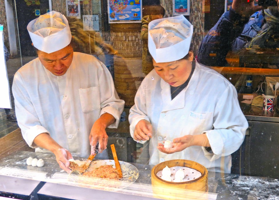 two chefs work in front of a sign that says pull