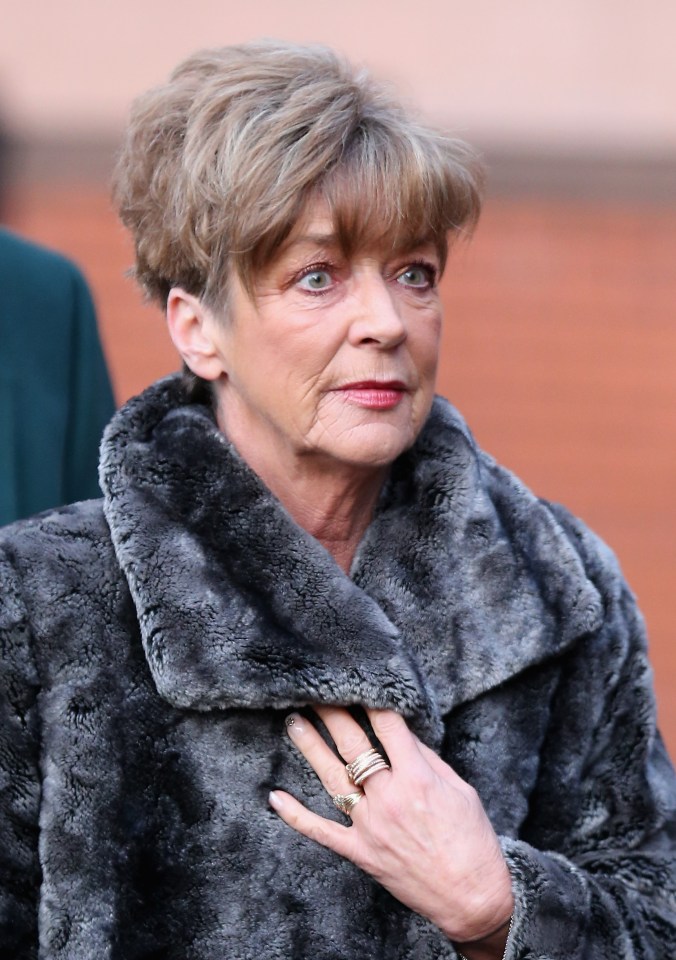 a woman wearing a fur coat has a ring on her finger