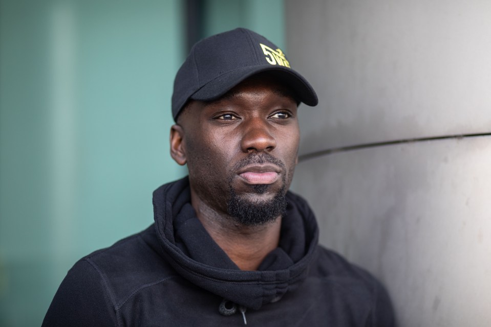 a man wearing a black hat with the number 5 on it