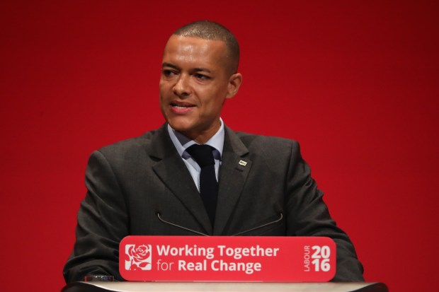 a man stands at a podium with a sign that says working together for real change