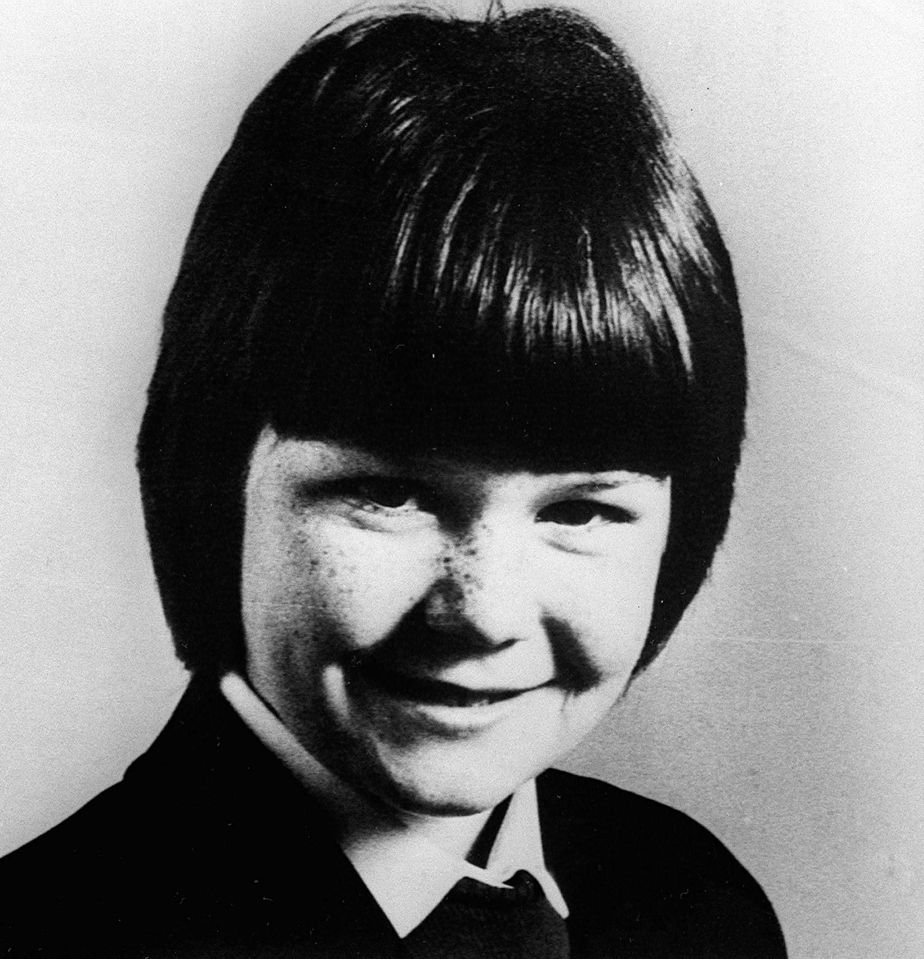 a black and white photo of a girl with short hair and freckles