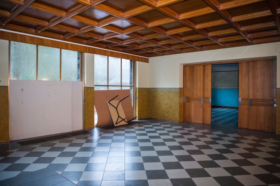 an empty room with a checkered floor and a wooden ceiling