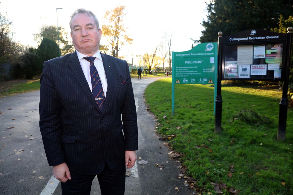 a man in a suit stands in front of a sign that says collingwood recreation ground