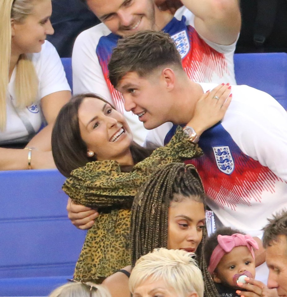 a man wearing an england jersey is hugging a woman